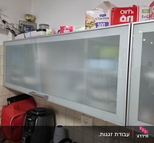 ארונות זכוכית במטבח עם מוצרי ניקוי